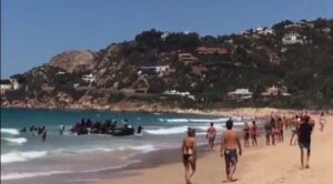 YOUTUBE Migranti sbarcano a Cadice tra i bagnanti in spiaggia e scappano