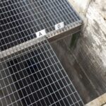 Cammina per strada e precipita in una grata aperta addosso a un operaio