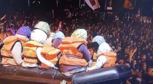 Un canotto carico di bambini con i salvagente, simbolo dei migranti nella Manica al Festival di Glastonbury