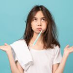 donna perplessa con spazzolino in bocca