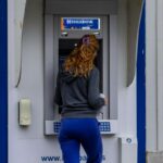 Una ragazza preleva al bancomat