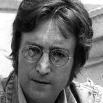 Primo piano in bianco e nero di John Lennon, con i suoi iconici occhialetti