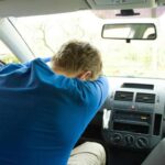 Un uomo dorme in auto