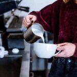 una ragazza prepara un cappuccino