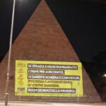 La facciata della Piramide Cestia a Roma con le scritte contro le Ong