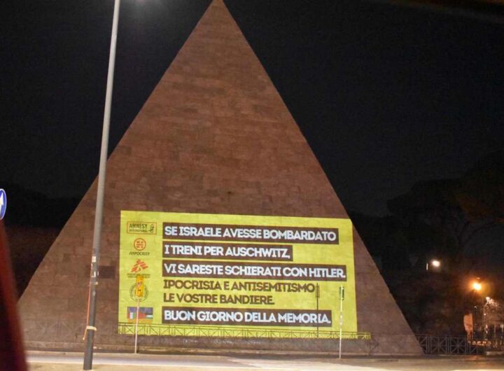 La facciata della Piramide Cestia a Roma con le scritte contro le Ong