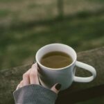 una ragazza con in mano una tazza di te verde