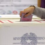 Una donna ripone la scheda elettorale nell'urna