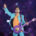 Prince sul palco durante un'esibizione, con la sua caratteristica chitarra viola
