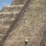 Turista che scala una piramide Maya