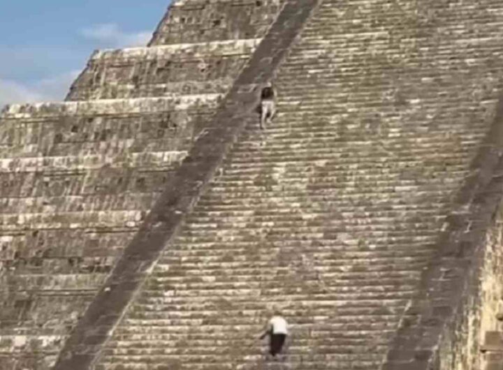 Turista che scala una piramide Maya