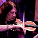 Scarlet Rivera, la violinista di Bob Dylan, con il suo violino durante un'esibizione