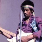 Jimi Hendrix fotografato con la sua chitarra durante un concerto