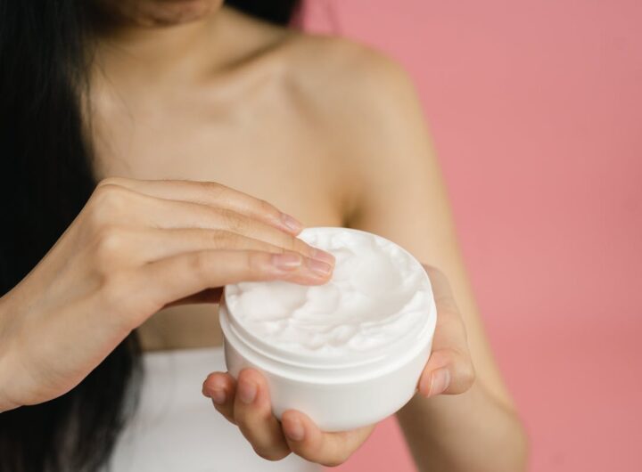 una ragazza si spalma la crema idratante