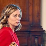 meloni in rosso sguardo severo ma felice per il rating