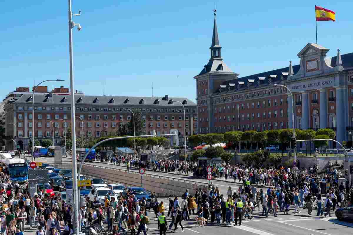 La foto del giorno, passeggeri della metro in strada a Madrid durante il blackout: auto ferme e semafori spenti