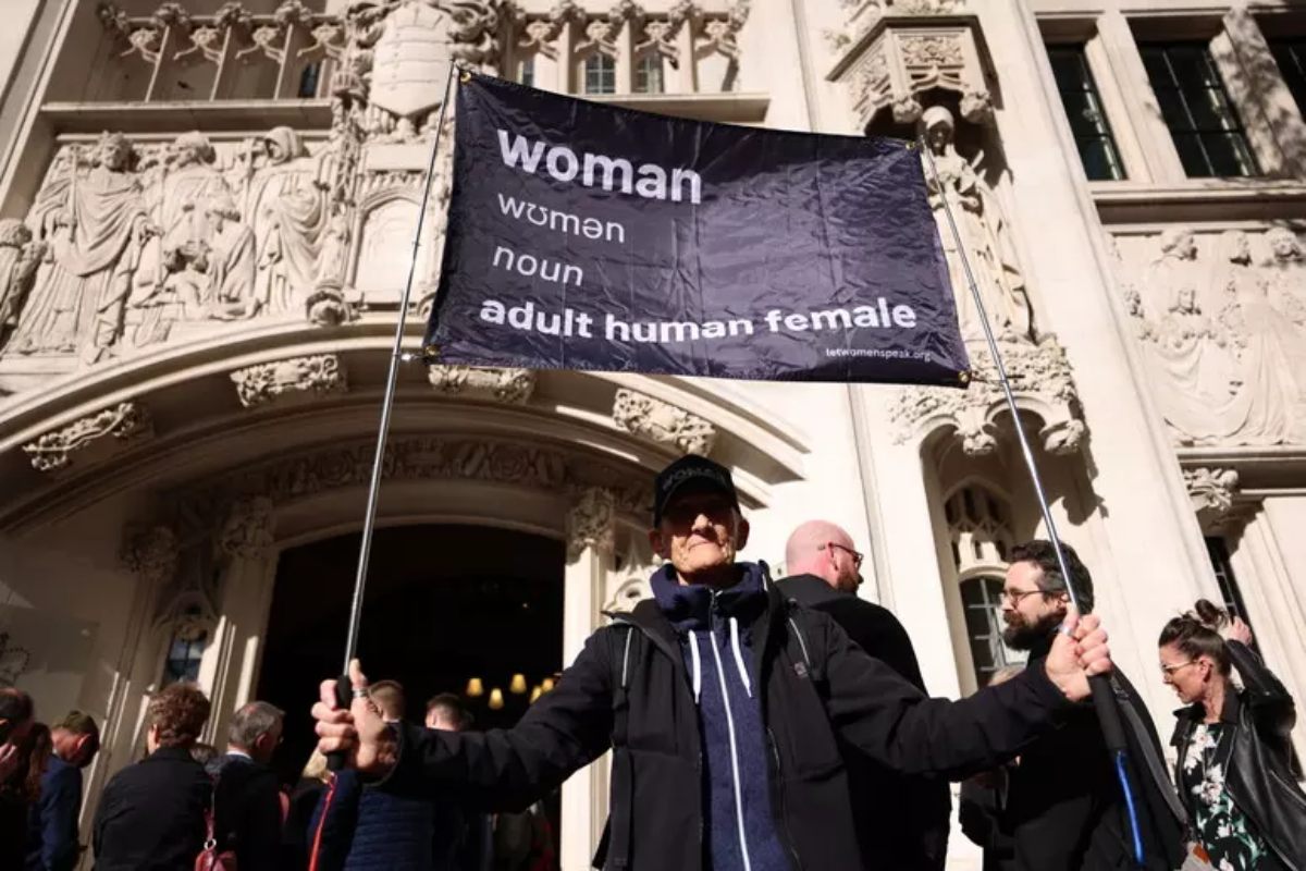 manifestante con cartello contro le donne trans