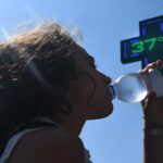 Donna beve per il caldo