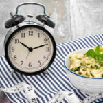 una sveglia accanto a un piatto