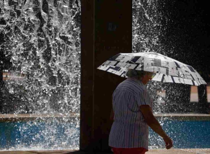 Una donna si ripara dal sole con un ombrello