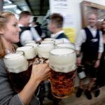 ragazza porta dei bicchieri di birra