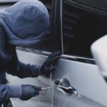 ladro tenta di aprire un'auto