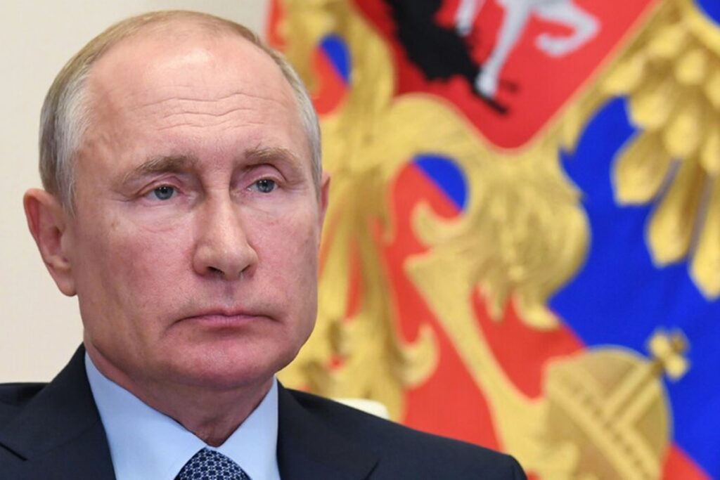 Trump ha subito, ora Zelensky e l’Europa devono ingoiare: le ragioni di Putin, le paure dei Baltici , Nela foto Vladimir Putin sullo sfondo della bandiera russa