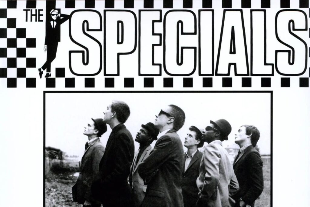 Un particolare dell'iconica copertina di The Specials, album di debutto degli Specials, con la scritta su sfondo a scacchi bianchi e neri e una foto della band in cui guardano tutti nella stessa direzione