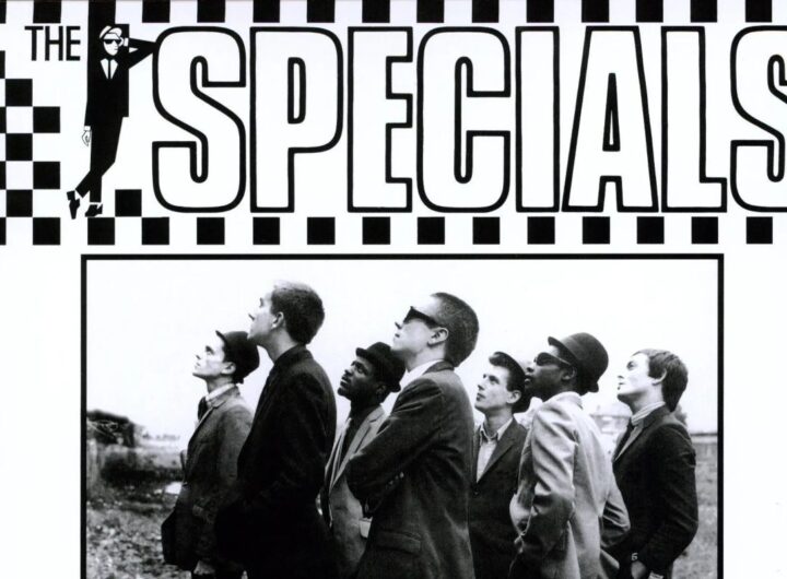 Un particolare dell'iconica copertina di The Specials, album di debutto degli Specials, con la scritta su sfondo a scacchi bianchi e neri e una foto della band in cui guardano tutti nella stessa direzione