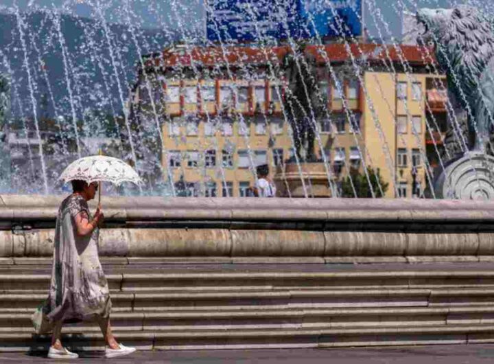 Donna di protegge dal sole con un ombrello
