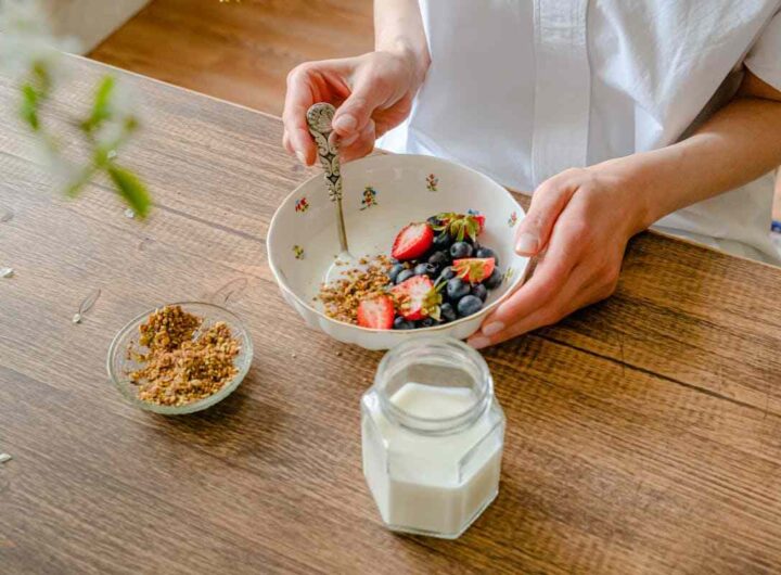 una donna fa colazione con yogurt e frutta