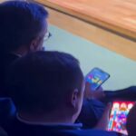 Sindacalisti giocano al cellulare durante l'intervento del ministro Urso