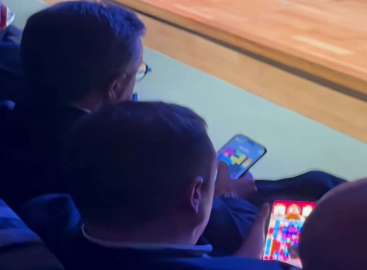 Sindacalisti giocano al cellulare durante l'intervento del ministro Urso