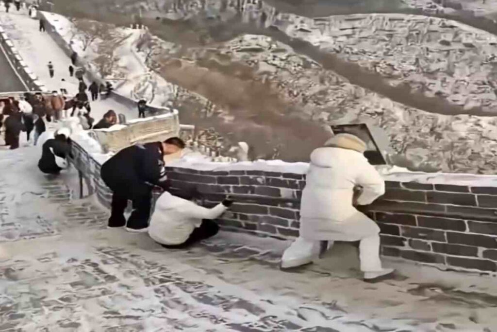 Neve e ghiaccio sulla Grande Muraglia in cina: i turisti provano a rimanere in equilibrio