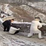 Neve e ghiaccio sulla Grande Muraglia in cina: i turisti provano a rimanere in equilibrio