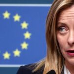 giorgia meloni con bandiera ue alle spalle
