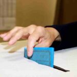 Uomo mette scheda elettorale nell'urna