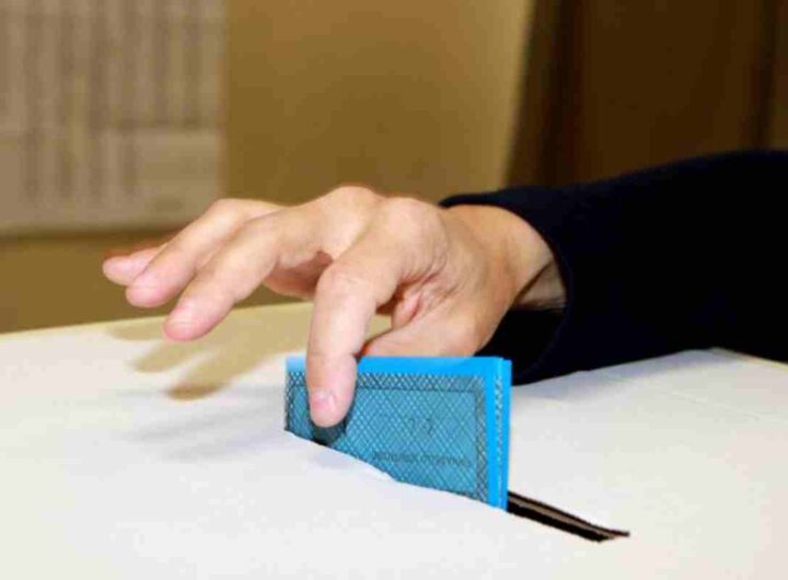 Uomo mette scheda elettorale nell'urna