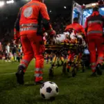 Giocatore trasportato in ospedale in ambulanza, immagine creata con intelligenza artificiale