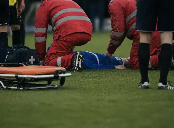 Calciatore soccorso in campo dallo staff medico, immagine creata con intelligenza artificiale
