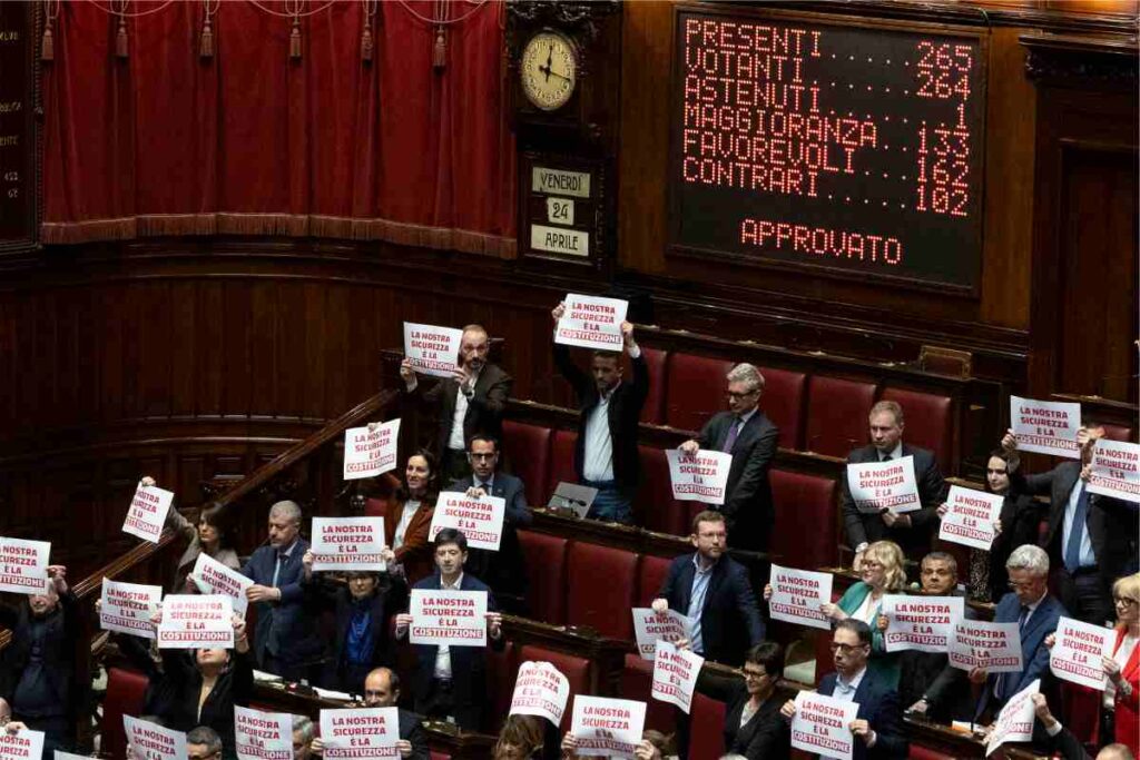 I cartelli mostrati dall'opposizione durante il voto per il Dl Sicurezza