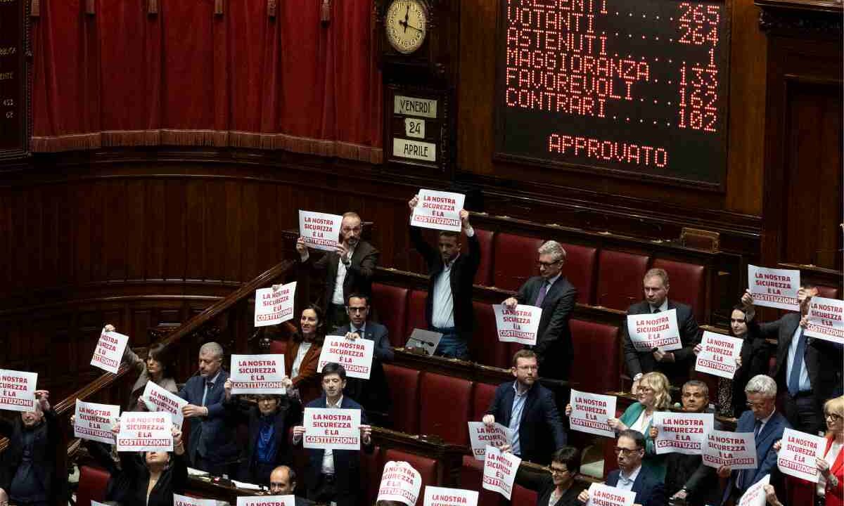 I cartelli mostrati dall'opposizione durante il voto per il Dl Sicurezza