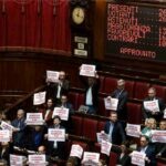 I cartelli mostrati dall'opposizione durante il voto per il Dl Sicurezza