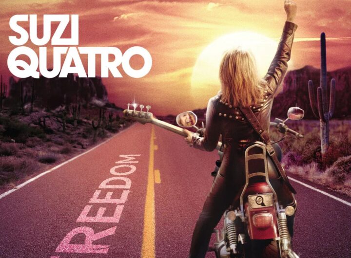 La copertina di Freedom di Suzi Quatro, con la bassista di spalle su una moto, con un basso in braccio, vestita di pelle, su una strada diretta verso il tramonto con la scritta "Freedom" e un braccio alzato verso il cielo