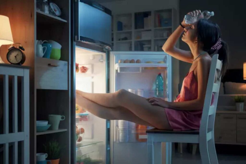 Una donna ha caldo e mette in piedi nel freezer