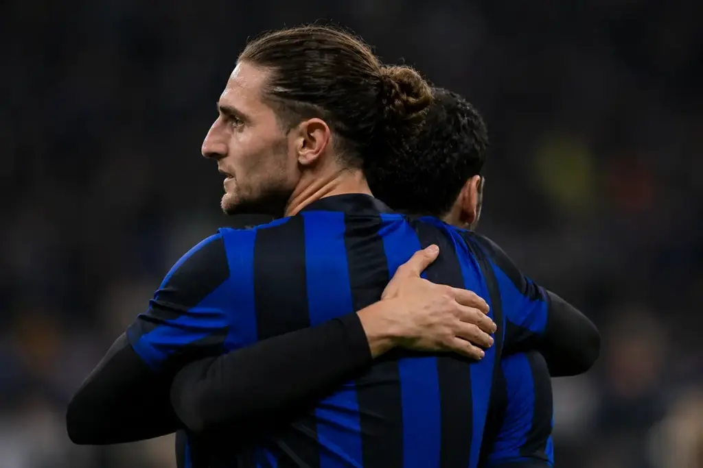 Rabiot abbraccia Calhanoglu con la maglia nerazzurra, immagine creata con intelligenza artificiale