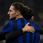 Rabiot abbraccia Calhanoglu con la maglia nerazzurra, immagine creata con intelligenza artificiale