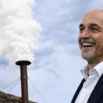 Spalletti sorridente e un comignolo dal quale esce fumo bianco