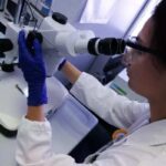 Una donna guarda al microscopio