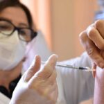 Una dottoressa vaccina un paziente